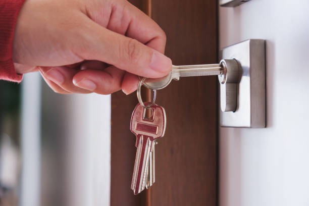 Hand turning a key in the front door of a new home
